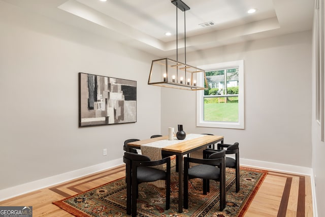 dining room featuring a raised ceiling, baseboards, and visible vents