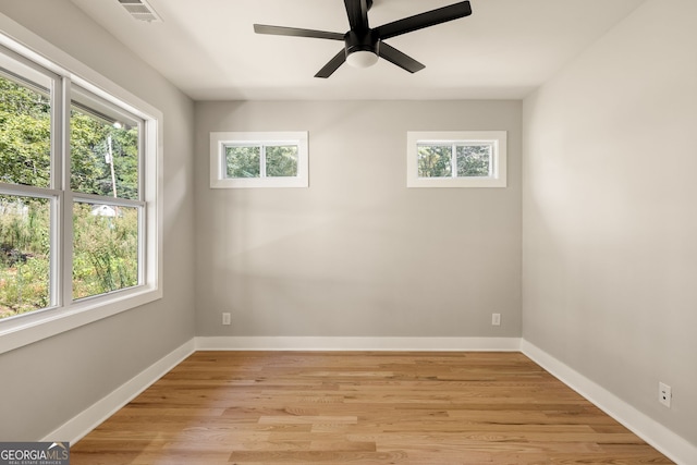 empty room with a wealth of natural light, visible vents, baseboards, and light wood-style floors