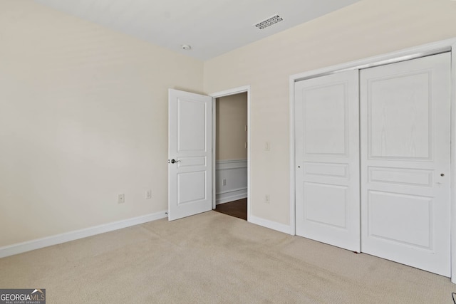 unfurnished bedroom featuring carpet floors, a closet, visible vents, and baseboards