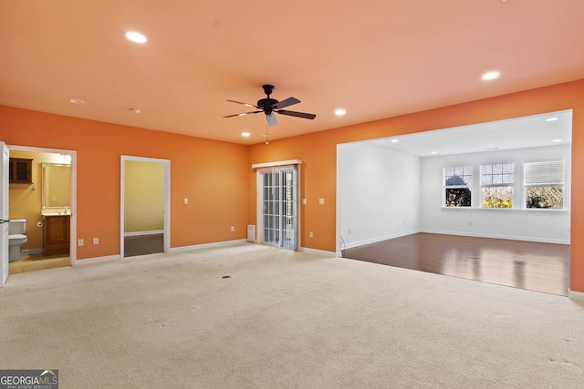 unfurnished living room with ceiling fan, baseboards, light colored carpet, and recessed lighting