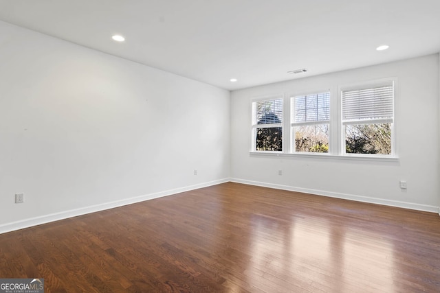 unfurnished room featuring dark wood-style floors, recessed lighting, visible vents, and baseboards