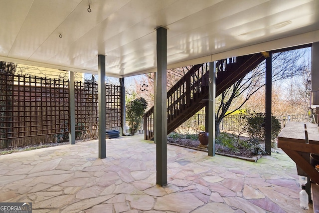 view of patio with fence and stairway