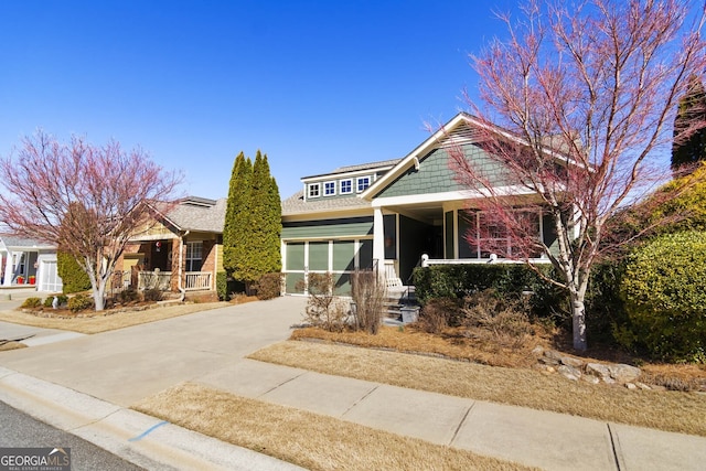 view of front of house featuring a garage, driveway, and a porch