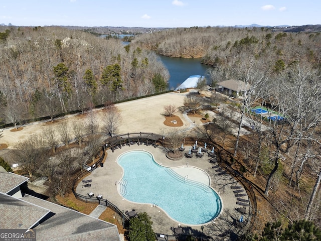 birds eye view of property with a water view and a wooded view