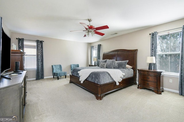 bedroom featuring light colored carpet, visible vents, ceiling fan, and baseboards