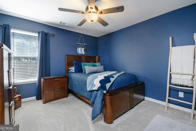 carpeted bedroom featuring a ceiling fan, visible vents, and baseboards