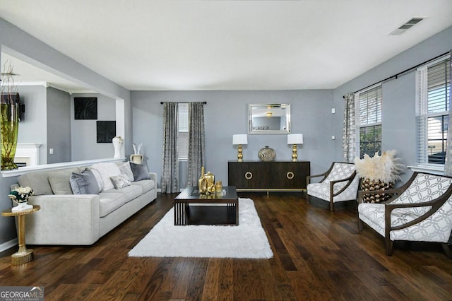 living area featuring visible vents and wood finished floors