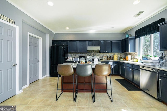 kitchen with under cabinet range hood, visible vents, stainless steel appliances, and decorative backsplash