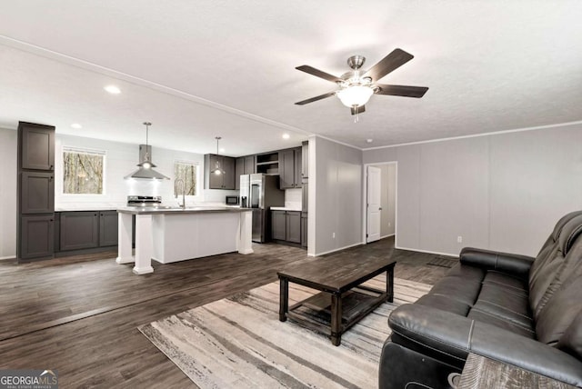 living room featuring dark wood-type flooring, a ceiling fan, and recessed lighting