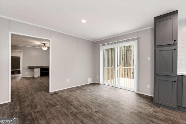 unfurnished living room featuring dark wood-type flooring, crown molding, baseboards, and a ceiling fan