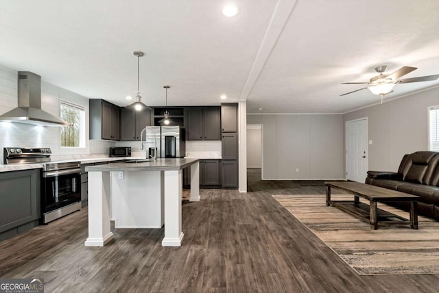 kitchen with dark wood-style floors, decorative backsplash, appliances with stainless steel finishes, open floor plan, and exhaust hood