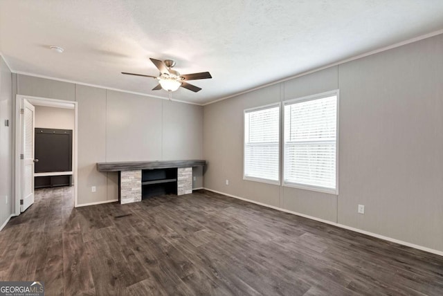 unfurnished office with a ceiling fan, baseboards, ornamental molding, and dark wood-type flooring