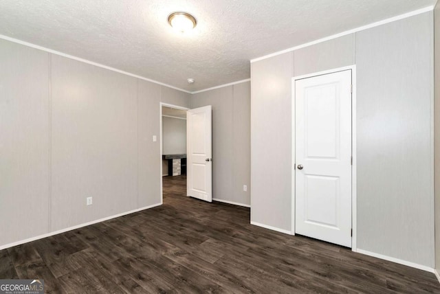 unfurnished bedroom featuring dark wood-type flooring, ornamental molding, and a textured ceiling