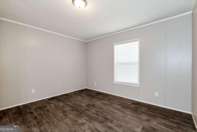 spare room featuring a textured ceiling, ornamental molding, a decorative wall, and dark wood-style flooring