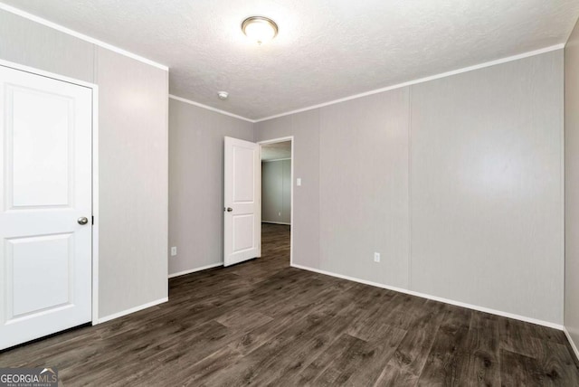 unfurnished bedroom with ornamental molding, a textured ceiling, baseboards, and wood finished floors