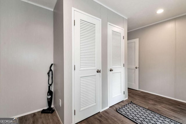 interior space with baseboards, wood finished floors, and crown molding