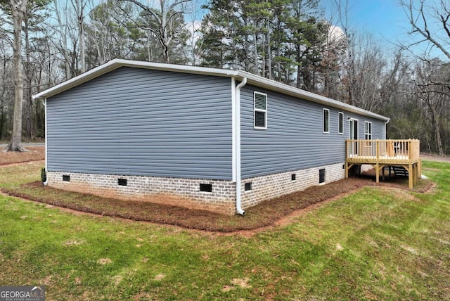 view of side of home featuring a deck, a yard, and crawl space