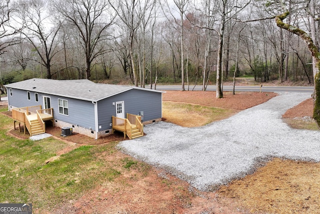 view of home's exterior featuring central AC, driveway, crawl space, and roof with shingles