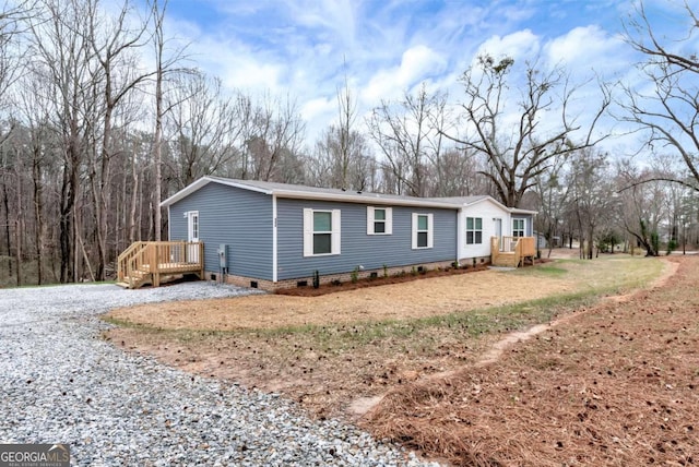 exterior space with a deck, driveway, and crawl space