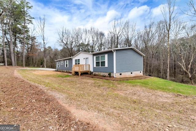 view of side of home featuring crawl space, a lawn, and a deck