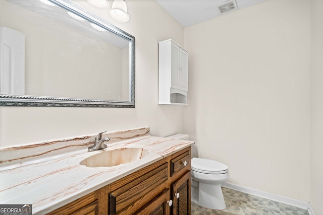 bathroom with vanity, toilet, baseboards, and visible vents