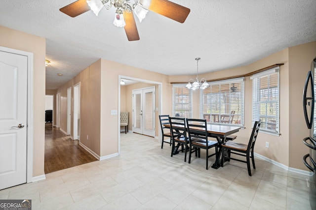 dining room with a notable chandelier, plenty of natural light, a textured ceiling, and baseboards