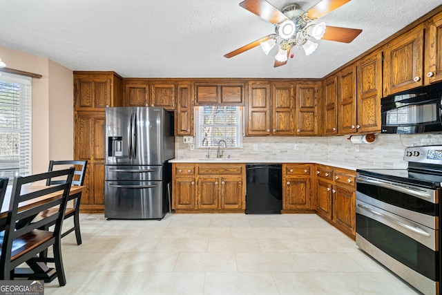 kitchen featuring plenty of natural light, black appliances, light countertops, and a sink