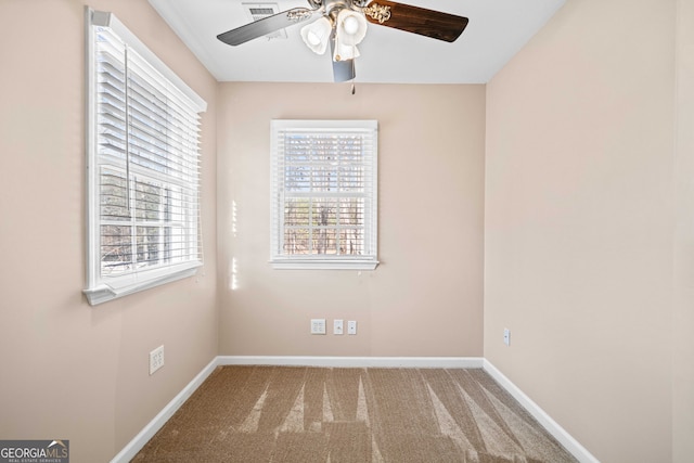 unfurnished room with carpet flooring, visible vents, a ceiling fan, and baseboards