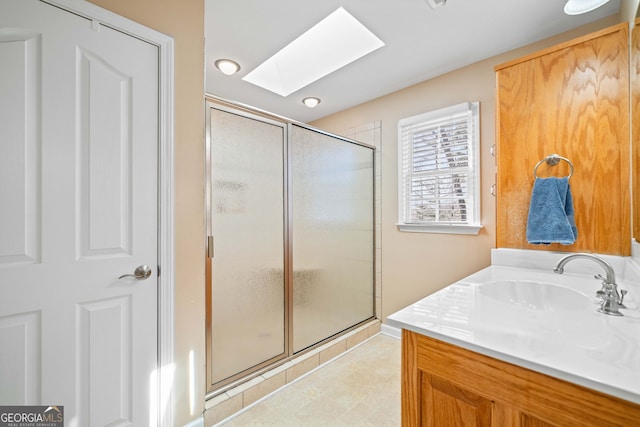 full bath with vanity, a skylight, and a stall shower