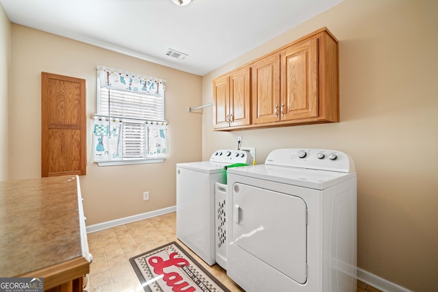 washroom featuring cabinet space, washing machine and dryer, visible vents, and baseboards