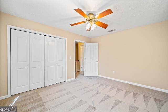 unfurnished bedroom with visible vents, baseboards, light colored carpet, and a closet