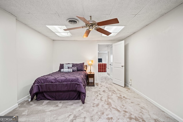 bedroom with a paneled ceiling, visible vents, carpet floors, and baseboards