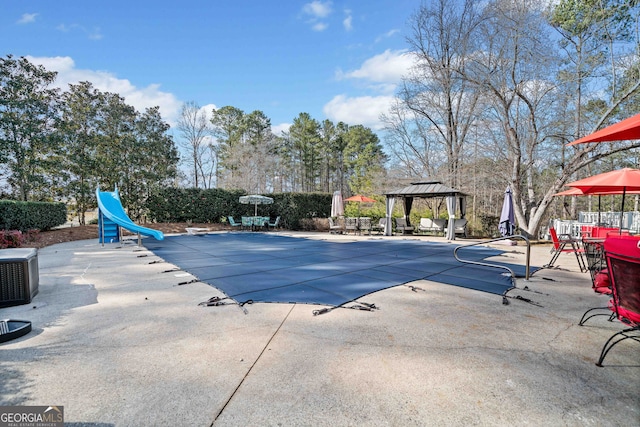 view of swimming pool with a gazebo, a fenced in pool, a patio, and a water slide