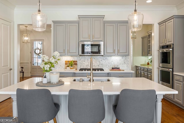 kitchen with appliances with stainless steel finishes, dark wood-style floors, gray cabinetry, and crown molding