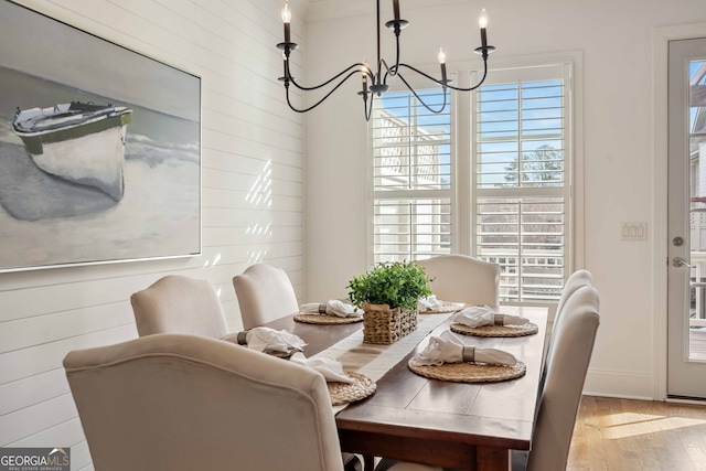 dining area featuring wood finished floors and a notable chandelier