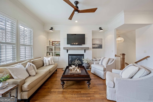 living room featuring ceiling fan, a fireplace, ornamental molding, recessed lighting, and wood finished floors