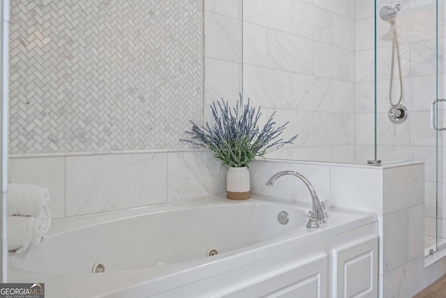 full bathroom with a tile shower, a tub with jets, and tile walls