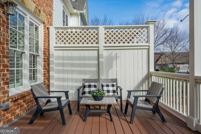 wooden terrace featuring outdoor lounge area and fence