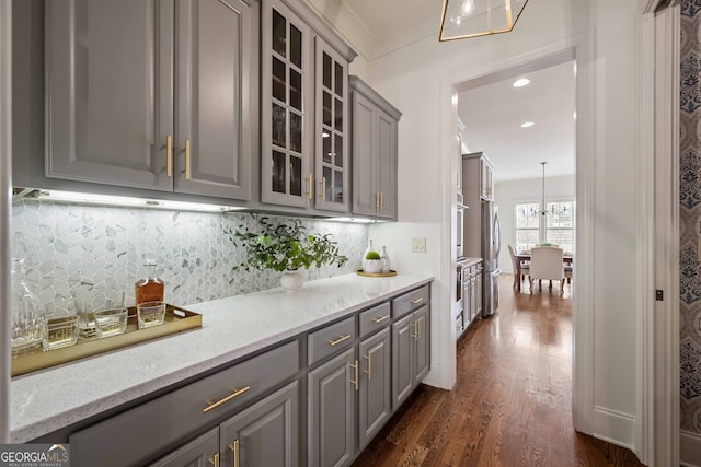 bar with tasteful backsplash, ornamental molding, recessed lighting, stainless steel appliances, and dark wood-style flooring