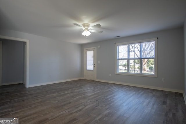 interior space featuring dark wood-style floors, visible vents, baseboards, and a ceiling fan