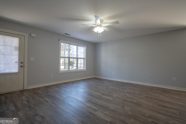 interior space featuring baseboards, visible vents, ceiling fan, and dark wood-type flooring