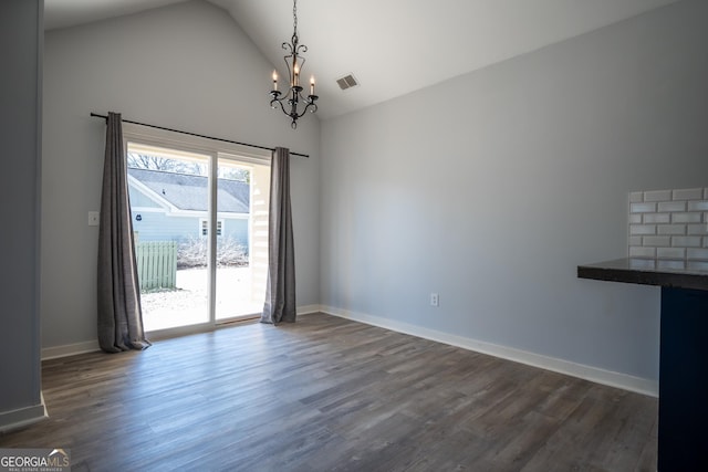 unfurnished dining area featuring a notable chandelier, dark wood finished floors, visible vents, and baseboards