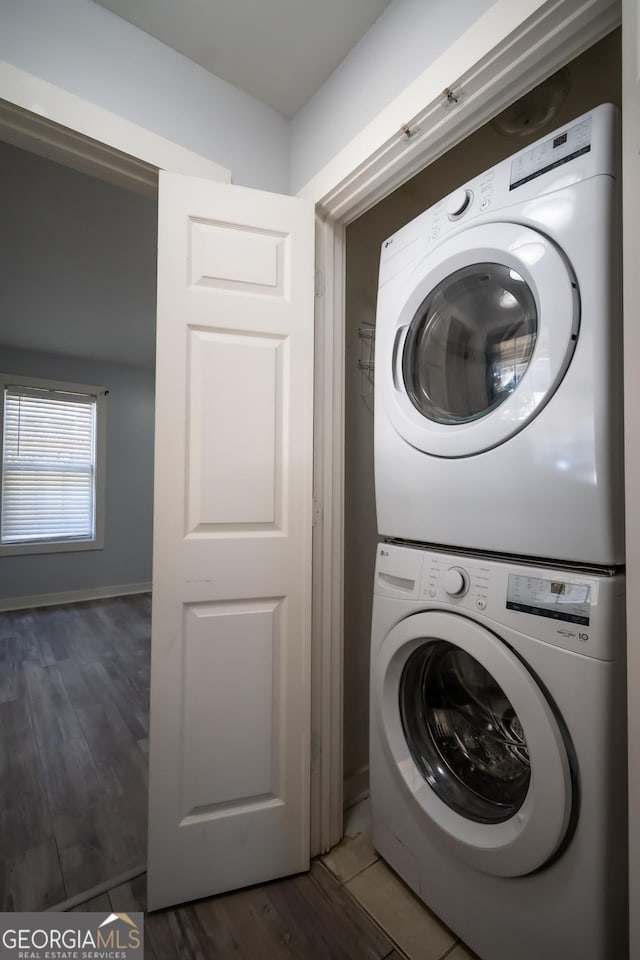 washroom with laundry area, stacked washing maching and dryer, and wood finished floors