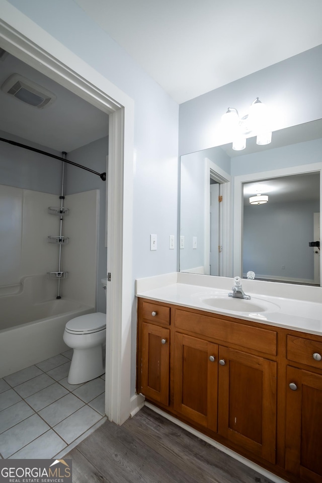 full bath with toilet, vanity, visible vents, tub / shower combination, and tile patterned floors