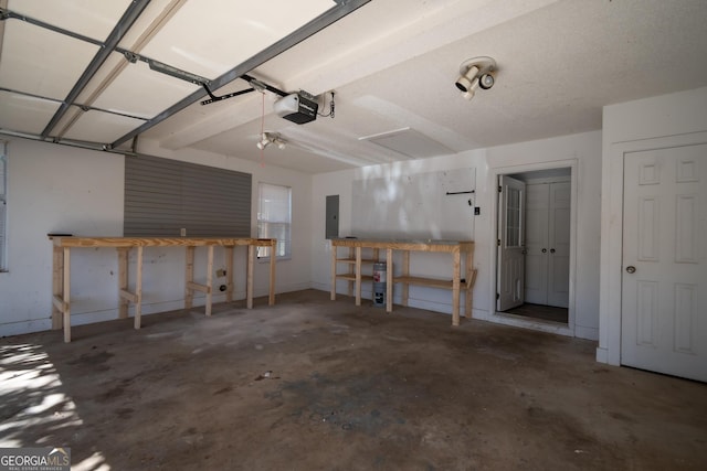 garage featuring a garage door opener, electric panel, and a workshop area