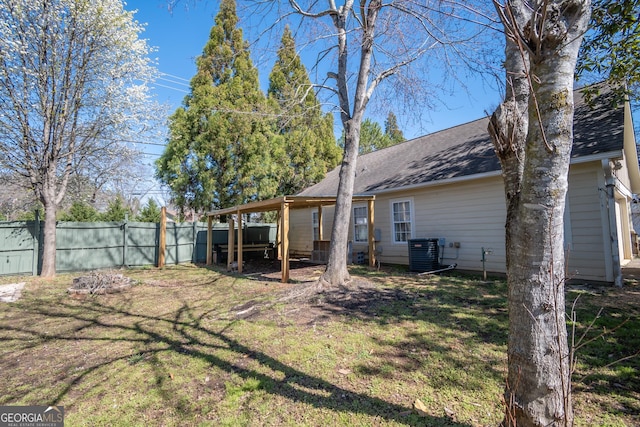 view of yard with fence and central AC unit