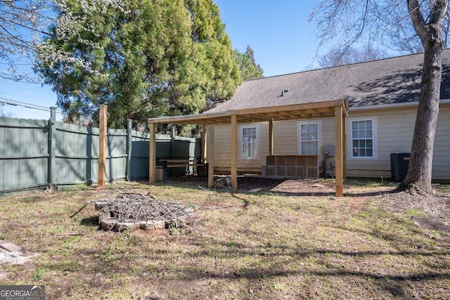 rear view of property with fence and roof with shingles