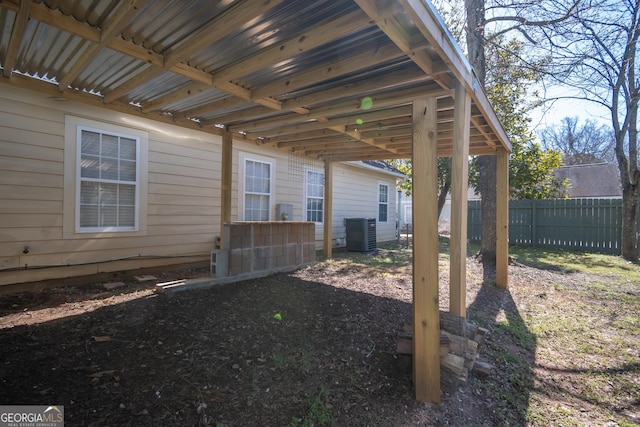 view of yard featuring fence and central AC