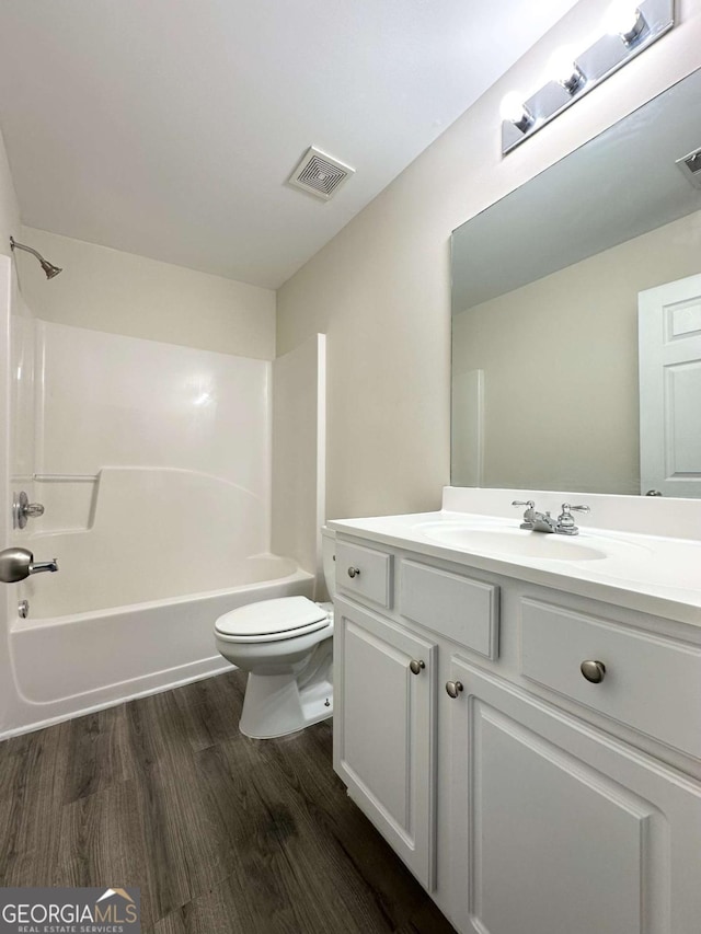 bathroom featuring bathtub / shower combination, toilet, wood finished floors, vanity, and visible vents