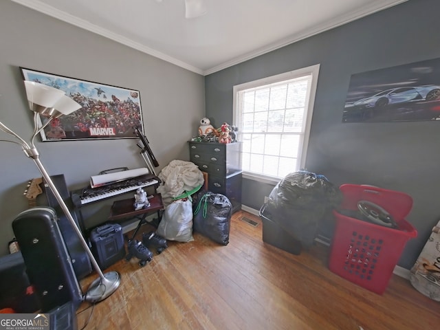 office area featuring baseboards, visible vents, ornamental molding, and wood finished floors